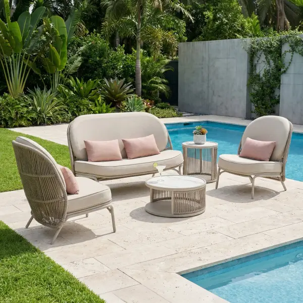 The Shell 5-Piece Lounge Set combines sculptural aluminum frames with woven rope texture and plush fade-resistant cushions in fresh coastal colors. Marble-look ceramic tables with hidden storage add refined functionality.