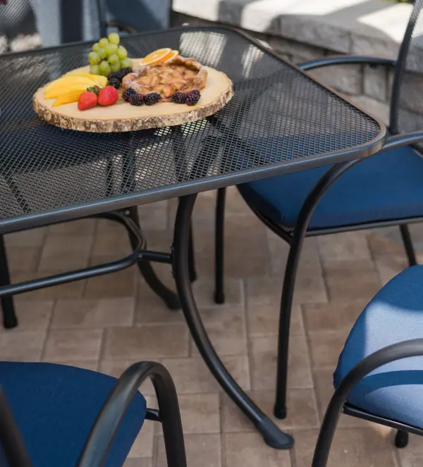 The Pilano dining set combines modern style with exceptional durability. Features proprietary Electrotherm coating that resists fading and stays cooler to touch. Includes 6 stackable mesh chairs and a 57x35 table with umbrella hole. - alternate view