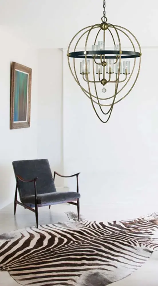 The Margaux chandelier combines antique brass warmth with modern matte black accents in a dramatic 35-inch wide design. Nine candle-style lights with seedy glass shades create sophisticated ambiance for large dining rooms and grand entryways. - alternate view
