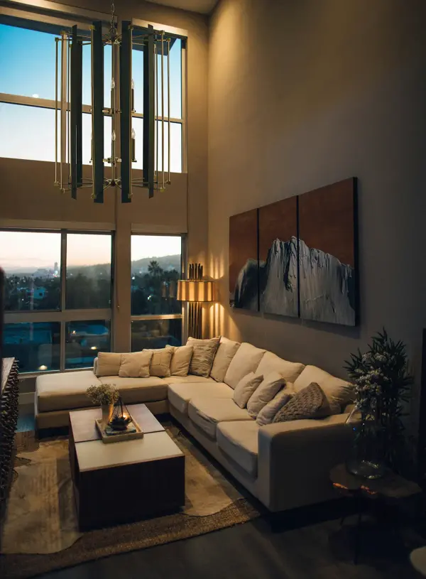 The Louvre chandelier makes a bold architectural statement with its generous 32-inch width and 12 candle-style lights. The striking combination of warm antique brass and modern matte black creates visual depth and versatility. - alternate view