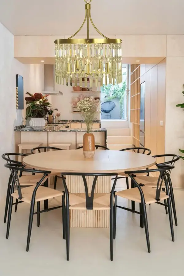 The Holly chandelier combines classic candle-style lighting with a contemporary brushed brass finish. At 24 inches wide, it's perfectly sized for medium dining spaces, offering versatile style that bridges traditional and modern aesthetics. - alternate view