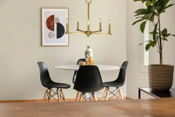 The Evelyn chandelier combines transitional elegance with contemporary simplicity. Its brushed brass finish adds warmth while the 5-light candle configuration provides ample illumination for dining spaces. Versatile design works across traditional and modern interiors. - alternate view