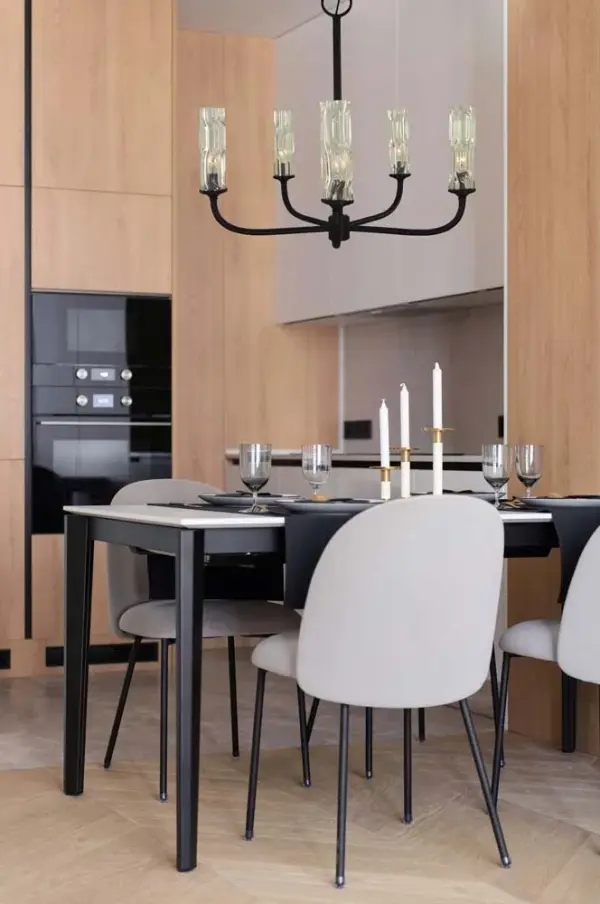 The Kaia 5-Light Chandelier combines matte black metal with clear wavy glass cylinders for a sophisticated transitional look. At 26 inches wide, it's perfectly sized for medium dining spaces and kitchen islands. - alternate view