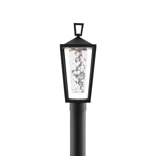 A thick hammered glass shade sends a textured glow from this modern wall lantern. An open cage frame and clean geometric accents provides added style.