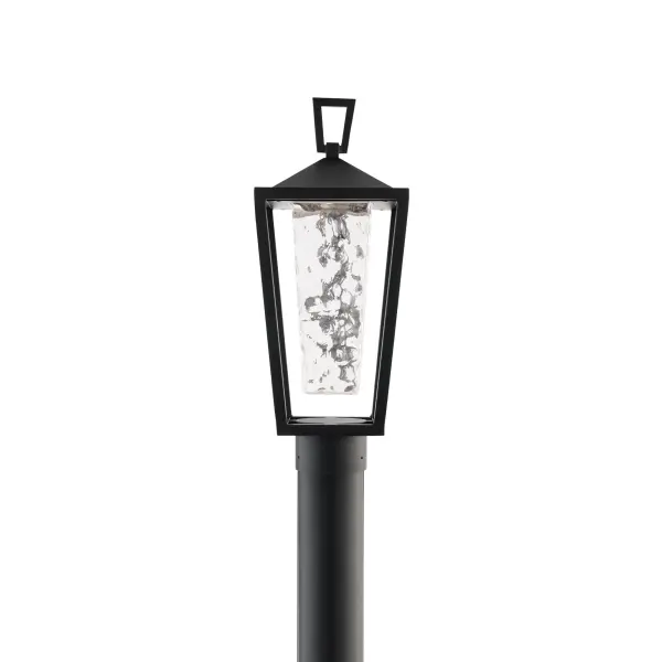 A thick hammered glass shade sends a textured glow from this modern wall lantern. An open cage frame and clean geometric accents provides added style.