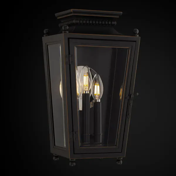 Classic charm merges with modern elegance. The Milton wall lantern’s subtle tapered design adds texture, while four petite ball feet provide a graceful, elevated stance. A stacked roof element enhances its architectural silhouette, complemented by a striking grey oxide, weather-resistant finish. Brass-trimmed doors with clear glass shades encase a trio of candle slips nestled within, while a round mirror on the lantern’s inside wall amplifies a warm, inviting glow.