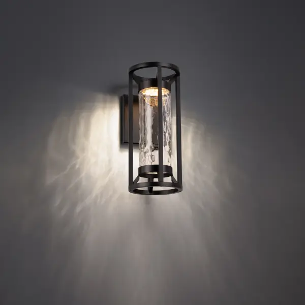 Like a beacon in the night, soft illumination beckons through a cylinder of hammered glass.