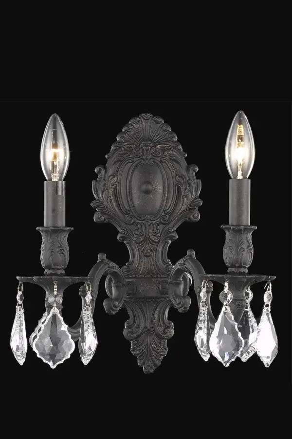 Regal and distinct, the Monarch collection of wall sconces flaunts a swirling vision of scrolls and crystal. A graceful oval backplate, accented with ornate curlicues, supports one, two, three, or five scrolled arms. The frame is finished in pewter, dark bronze, or French gold. Sculpted candle holders add to the dramatic effect, while the soft candelabra lights (bulbs not included) add the finishing touch to this spectacular design. A majestic addition to an entryway, office, or bathroom. Collection: Monarch Rooms: Hallway, Living room, Bedroom, Bathroom, Entry Way, Finish: Dark Bronze Crystal: clear Notes: Royal Cut Crystal (Clear) Width: 10.00" Height: 11.50" Length: 10.00" Weight: 5.00 lb Extension from Wall: 7.50" Wire: 23.62" Canopy: 3.46``x11.34`` Number of Bulbs: 2 Maximum Wattage: 40.00 W Bulb Type: B10 Bulb Base: E12 Dimmable Voltage: 110.00 V Material: Brass and Crystal Country of Origin: China Safety Listing: UL / Ulc Safety Rating: Damp Title 20 Title 24 Manufacturer Warranty: 1 year limited
