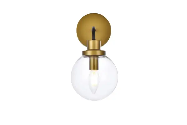 In all of its auspicious glory, the Hanson collection wall lamp will shine its felicitous light for you. As the light passes through the shade, it dances around with the shadows and puts a spotlight in your room. Whether it is in your entryway or bathrooms, this 1-light wall lamp will surely please you and your guests. Collection: Hanson Rooms: Dining room, kitchen, living room, entry way Finish: Black and Brass and Clear Shade Glass: Clear Width: 8.50" Height: 11.70" Length: 6.00" Weight: 2.00 lb Extension from Wall: 8.50" Wire: 6" Black and White Canopy: 4.7"x4.7"x1" Number of Bulbs: 1 Maximum Wattage: 40.00 W Bulb Type: E12 Bulb Base: E12 Dimmable Voltage: 110.00 V Material: Metal and Aluminum and Glass Country of Origin: China Safety Listing: ETL Safety Rating: Damp Title 20 Title 24 Manufacturer Warranty: 1 year limited Spec Sheet