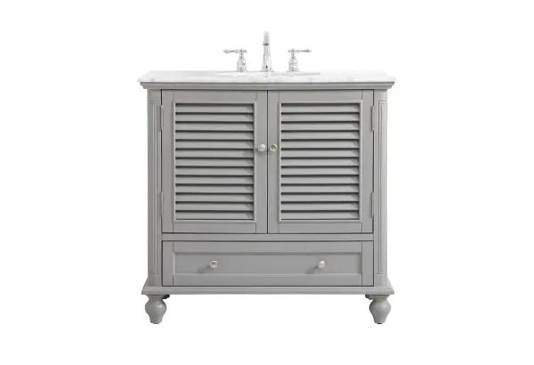 The Rhodes collection compact vanity will add lovely sophistication and complement any small bathroom or powder room, while utilizing its charm and function to provide you with ample storage spaces. Metal round knobs gently adorn the shuttered cabinet door and drawer at the base, allowing for you to store away your bathroom essentials. The Carrara white marble countertop, porcelain undermount sink, dignified subtle engravings on the side edges, and rounded legs all come together to create contemporary beauty. Work with your space, and design a beautiful room, no matter the size. Collection: Rhodes Rooms: bathroom Finish: Grey Width: 22.00" Height: 35.00" Length: 36.00" Weight: 125.00 lb Material: Solid wood and MDF Country of Origin: Vietnam Manufacturer Warranty: 1 year limited Spec Sheet