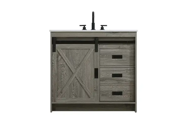 Transform your bathroom with this rustic barnyard-style vanity, designed to balance aesthetic appeal and functionality. Featuring a sliding barn door with black metal hardware and complementary handle pulls, this piece blends rugged charm with practical design. The engineered marble countertop displays unique marbling, while the porcelain undermount sink offers easy maintenance and durability. Available in Espresso, Natural Oak, and Rustic Grey finishes, this vanity suits a range of styles. It includes a deep storage drawer for larger items, a hidden shelf for towels or décor, and adjustable foot levelers for added stability on uneven floors. With pre-drilled faucet holes for easy setup, this vanity delivers style and substance to enhance your bathroom. Collection: Austin Rooms: bathroom Finish: Rustic Grey Width: 36.00" Height: 22.00" Length: 36.00" Weight: 147.00 lb Material: MDF Country of Origin: Malaysia Manufacturer Warranty: 1 year limited