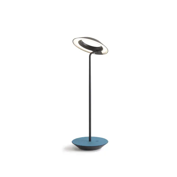 The Royyo Desk lamp adds an elegant flair to any space with its minimal wiring and pleasing circular design. Its minimal silhouette houses complex inner technology for a marriage of form and functionality. Royyo's embedded USB port allows users to charge any USB - compatible device. Interchangeable base plate options allow users to customize at ease. Achieve unity in design by inviting the Royyo Floor Lamp, Royyo Pendant and Royyo Desk Lamp into your home. Collection: Royyo Designer: Kenneth Ng, Edmund Ng Finish: Matte Black, Azure Felt Width: 6.40" Height: 17.40" Length: 6.40" Weight: 2.60 lb Bulbs Included Maximum Wattage: 11.00 W Bulb Type: LED Bulb Base: Integrated Light Source: LED Light Output: 600.00 lm Color Temperature: 3000 K CRI: 90 Voltage: 120.00 V Material: Aluminum, plastic Country of Origin: China Safety Listing: UL, CUL Safety Rating: Damp LED Manufacturer Warranty: 5 years Spec Sheet
