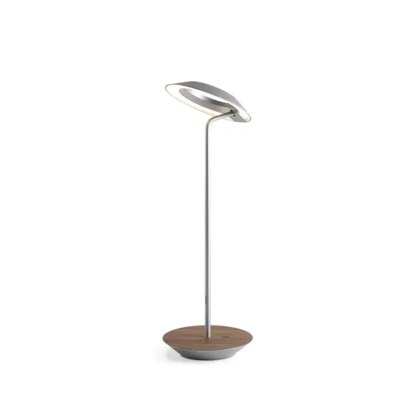 The Royyo Desk lamp adds an elegant flair to any space with its minimal wiring and pleasing circular design. Its minimal silhouette houses complex inner technology for a marriage of form and functionality. Royyo's embedded USB port allows users to charge any USB - compatible device. Interchangeable base plate options allow users to customize at ease. Achieve unity in design by inviting the Royyo Floor Lamp, Royyo Pendant and Royyo Desk Lamp into your home. Collection: Royyo Designer: Kenneth Ng, Edmund Ng Finish: Silver, Oiled Walnut Width: 6.40" Height: 17.40" Length: 6.40" Weight: 2.60 lb Bulbs Included Maximum Wattage: 11.00 W Bulb Type: LED Bulb Base: Integrated Light Source: LED Light Output: 600.00 lm Color Temperature: 3000 K CRI: 90 Voltage: 120.00 V Material: Aluminum, plastic Country of Origin: China Safety Listing: UL, CUL Safety Rating: Damp LED Manufacturer Warranty: 5 years Spec Sheet