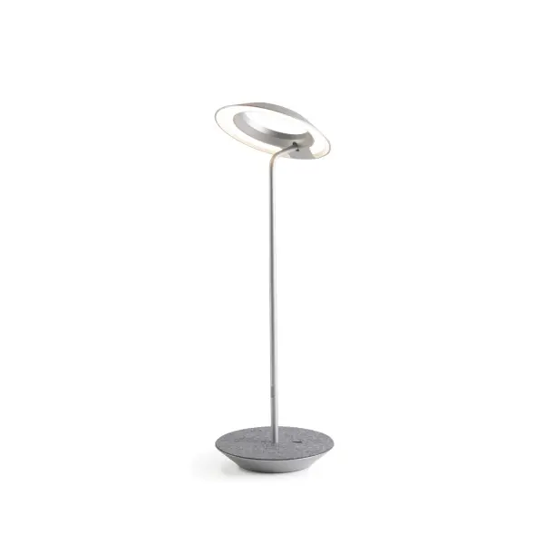 The Royyo Desk lamp adds an elegant flair to any space with its minimal wiring and pleasing circular design. Its minimal silhouette houses complex inner technology for a marriage of form and functionality. Royyo's embedded USB port allows users to charge any USB - compatible device. Interchangeable base plate options allow users to customize at ease. Achieve unity in design by inviting the Royyo Floor Lamp, Royyo Pendant and Royyo Desk Lamp into your home. Collection: Royyo Designer: Kenneth Ng, Edmund Ng Finish: Silver, Oxford Felt Width: 6.40" Height: 17.40" Length: 6.40" Weight: 2.60 lb Bulbs Included Maximum Wattage: 11.00 W Bulb Type: LED Bulb Base: Integrated Light Source: LED Light Output: 600.00 lm Color Temperature: 3000 K CRI: 90 Voltage: 120.00 V Material: Aluminum, plastic Country of Origin: China Safety Listing: UL, CUL Safety Rating: Damp LED Manufacturer Warranty: 5 years Spec Sheet