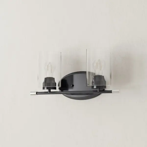 The Riley vanity light combines clean modern lines with clear glass cylinders and brushed nickel hardware. Perfect for contemporary bathrooms, this two-light fixture provides excellent task lighting while maintaining a sleek profile.