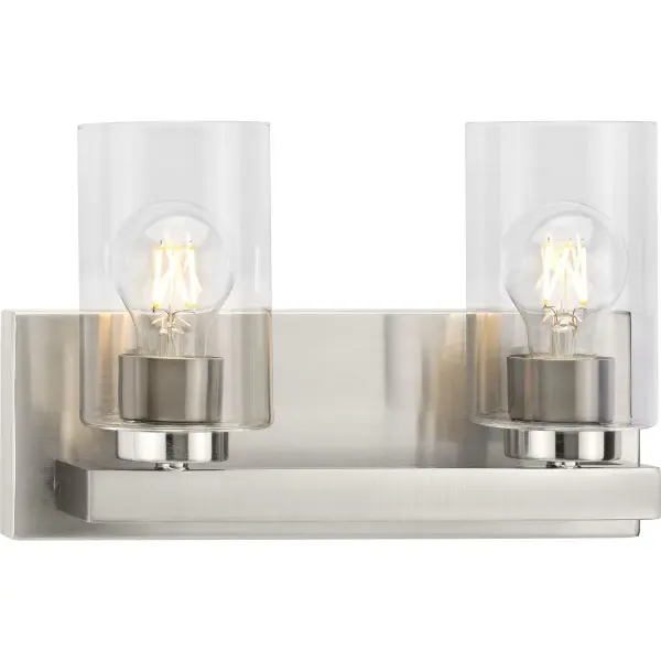The Goodwin two-light vanity fixture combines brushed nickel finish with clear glass shades for a refined, modern look. Perfect for bathrooms and powder rooms seeking contemporary style with excellent task lighting.
