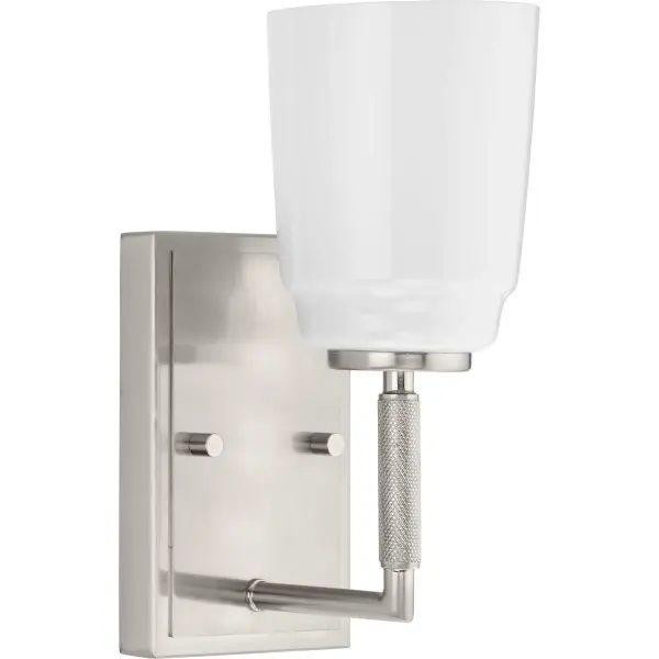 The Spenser vanity light blends modern farmhouse charm with industrial styling in a compact one-light design. Its brushed nickel finish and clear glass shade provide versatile appeal for contemporary bathrooms. - alternate view