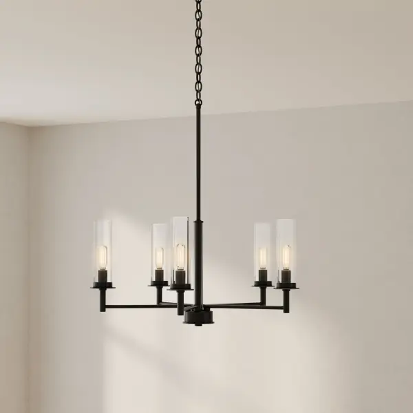 The Kellwyn chandelier combines transitional styling with contemporary clean lines, featuring five lights encased in clear glass shades. The brushed nickel finish adds sophistication while maintaining versatility across design schemes. - alternate view