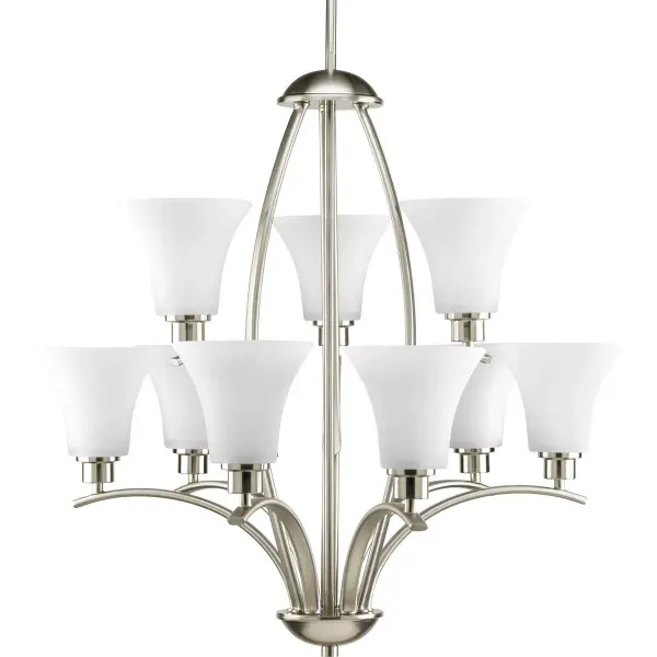 The Joy chandelier combines classic elegance with contemporary styling, featuring 9 lights and etched white glass shades. Its substantial 28-inch width and brushed nickel finish make it a versatile centerpiece for dining rooms and entryways. - alternate view