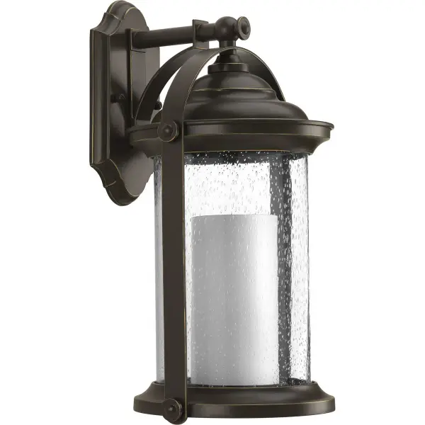 The Whitacre wall lantern blends traditional craftsmanship with transitional styling in a durable Antique Bronze finish. Perfect for porches and patios, it offers timeless appeal with modern energy efficiency.