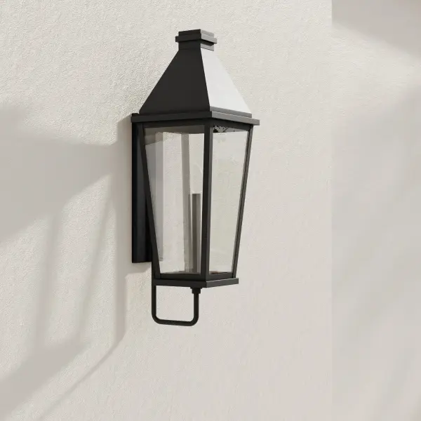 The Richmond Hill wall lantern combines clean modern lines with farmhouse charm in a large-scale design. Clear glass panels showcase the light source while black finish provides bold contrast against exterior walls.