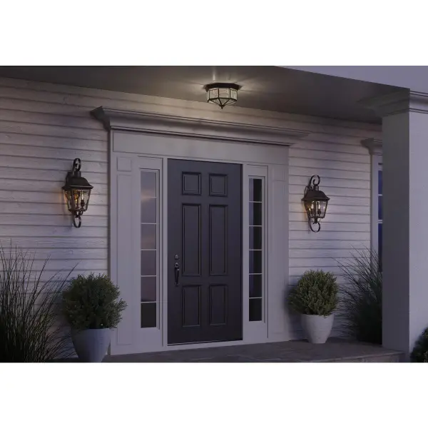 The Andover wall lantern brings traditional elegance to outdoor spaces with its antique bronze finish and clear glass panels. Perfect for porches, patios, and entryways, this medium-sized fixture provides ample illumination while enhancing curb appeal. - alternate view