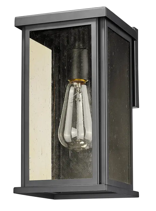 The Lyons wall sconce combines industrial charm with transitional elegance. Its matte black steel construction and champagne seedy glass create warm, ambient lighting perfect for outdoor entryways and patios.