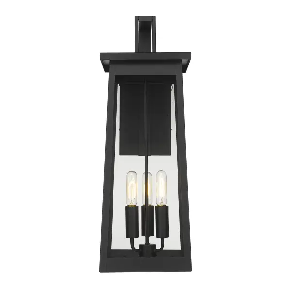 The Alden 3-Light Wall Sconce combines transitional elegance with industrial durability in a striking matte black finish. Its generous 29-inch height and clear glass panels create dramatic illumination for outdoor spaces. - alternate view