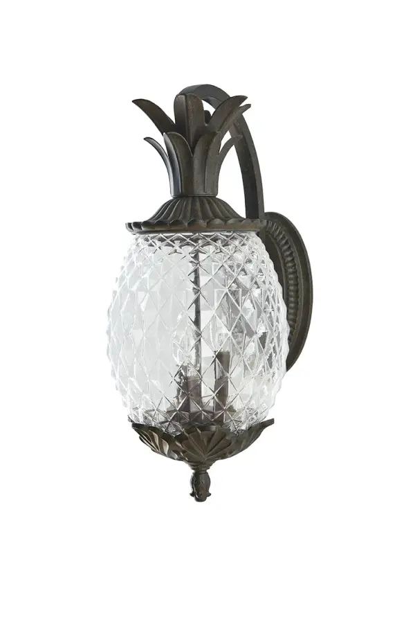 The Lanai 3-Light Wall Sconce brings coastal charm to outdoor spaces with its cast aluminum construction and unique pineapple-cut glass globes. The Black Coral finish offers durability and style for entryways and patios.