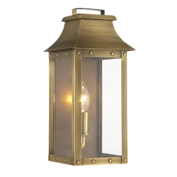 The Manchester wall sconce combines solid brass construction with traditional styling, featuring clear glass and an aged brass finish. Its compact 13.25" height makes it ideal for flanking doors or illuminating outdoor spaces.