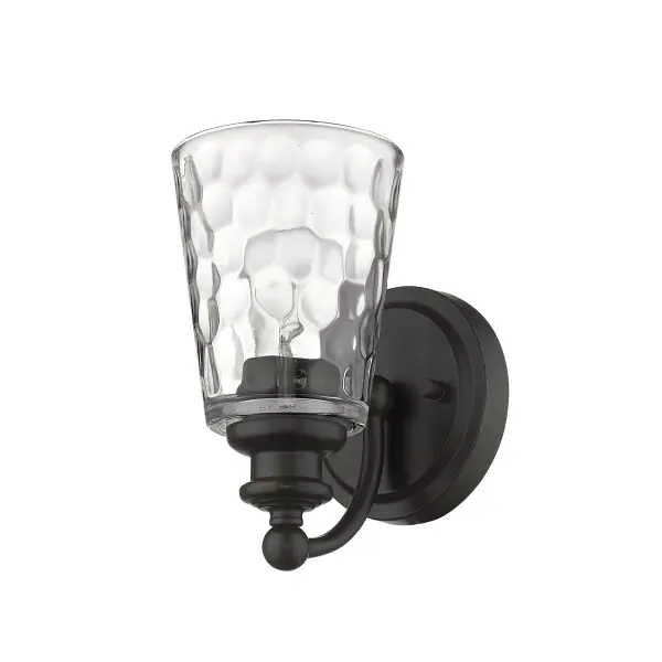 The Mae wall sconce combines industrial charm with transitional elegance through its oil-rubbed bronze finish and hand-blown clear optic glass. At 8.5" tall, it's perfectly sized for vanity lighting or accent illumination.