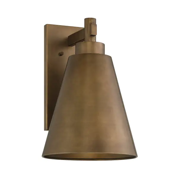The Ryder outdoor wall sconce combines rustic charm with responsible lighting design. Its Dark Sky friendly construction directs light downward to reduce light pollution while the solid metal shade in Atlas Bronze finish adds architectural character to any exterior space. - alternate view