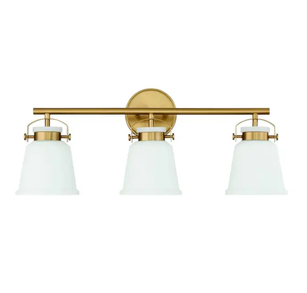 The Kaden 3-light vanity combines timeless design with industrial-inspired hardware in a warm brass finish. White opal glass shades provide even, flattering illumination perfect for bathroom tasks. Damp-rated for reliability. - alternate view