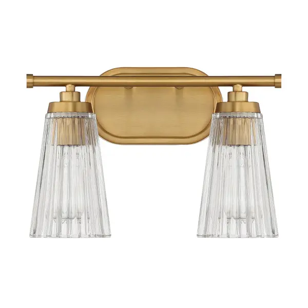 The Chantilly vanity light combines textured clear ribbed glass shades with a warm brass finish for a sophisticated bathroom upgrade. Compact 14-inch width fits most vanity spaces while providing ample illumination.