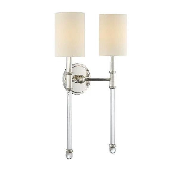 The Fremont sconce combines polished nickel metalwork with clear glass arms and soft white fabric shades for a refined, versatile look. Its slender 13-inch profile and decorative double-ring detailing make it ideal for pairing in multiples.