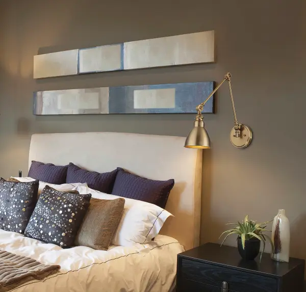 The Dakota wall sconce combines classic styling with modern functionality through its adjustable arm design. The warm brass finish adds a sophisticated touch that works across multiple decor styles, making it ideal for bedside reading or workspace task lighting. - alternate view