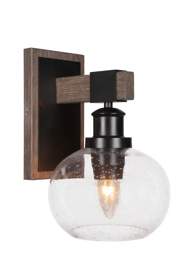The Tacoma Wall Sconce combines matte black metal with distressed wood-look accents and a charming 7-inch clear bubble glass shade. Its compact size and reversible mounting make it perfect for adding rustic industrial style to any space.