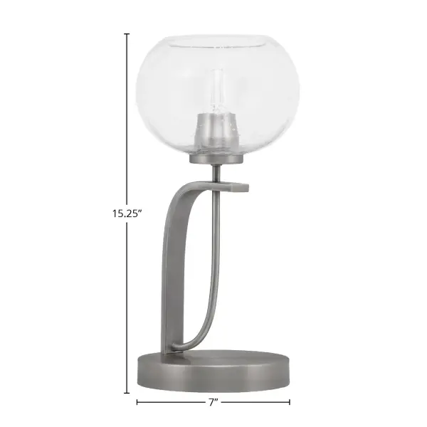 The Cavella Accent Lamp combines contemporary design with industrial charm through its graphite finish and unique 7-inch clear bubble glass shade. At 15.25 inches tall, it provides ambient lighting perfect for nightstands and accent tables. - alternate view