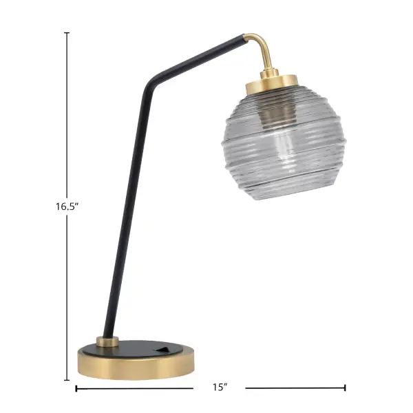 This striking desk lamp combines matte black and new age brass finishes with a 6" smoke ribbed glass shade, creating a perfect blend of industrial style and modern elegance for any workspace or bedroom. - alternate view