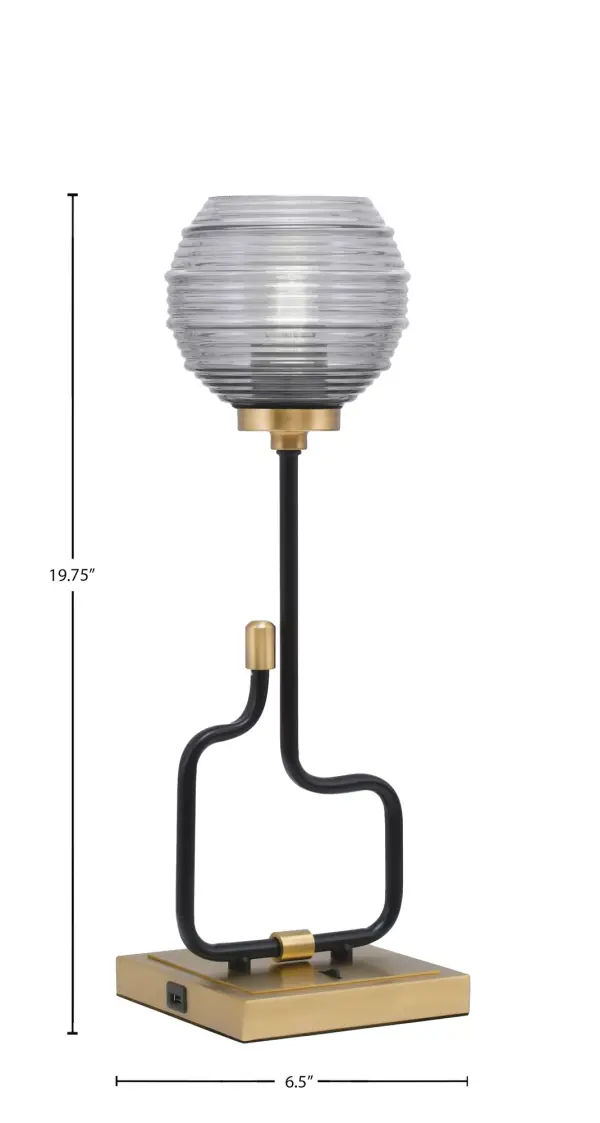 The Sandia Accent Lamp combines contemporary style with practical functionality. Its matte black and aged brass finish creates visual interest, while the smoke ribbed glass shade adds texture and warmth. Built-in USB ports make it perfect for modern living. - alternate view
