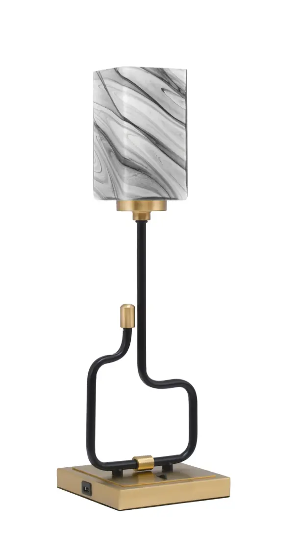 The Sandia Accent Lamp combines contemporary style with practical functionality. Featuring a striking matte black and aged brass finish with unique onyx swirl glass shade, this compact lamp includes built-in USB ports for device charging.