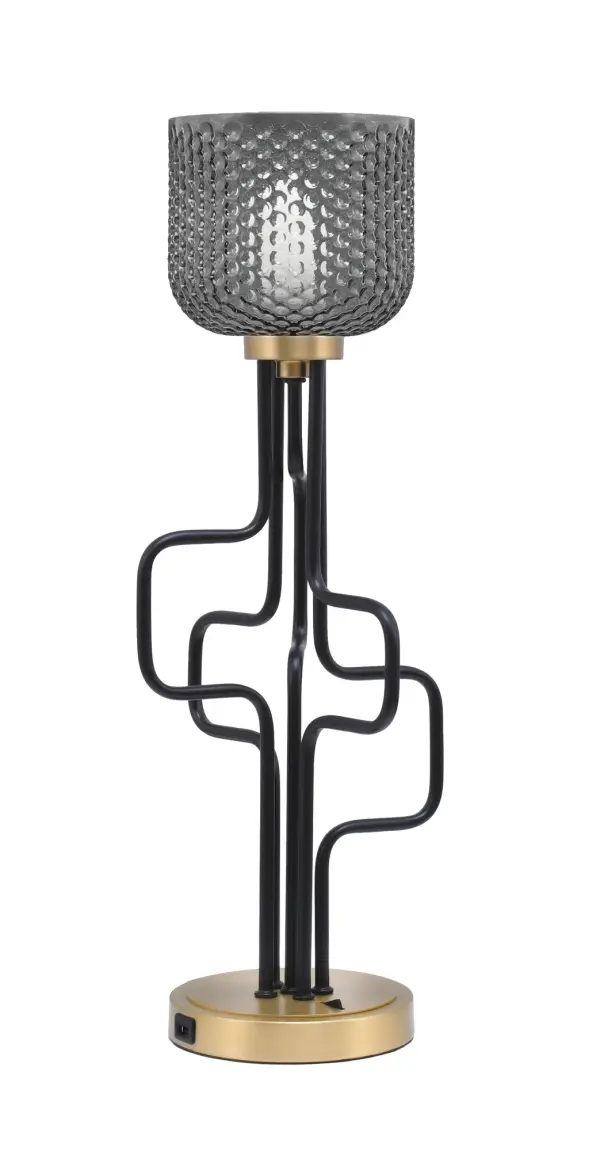 The Sandia Accent Lamp combines contemporary style with practical functionality. Featuring a striking matte black and aged brass finish with smoke textured glass, it includes built-in USB ports for device charging.