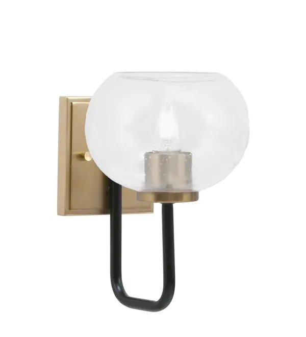 The Sandia Wall Sconce combines matte black and brass finishes for a sophisticated modern look. Its 7-inch clear bubble glass shade adds texture and visual interest while diffusing warm light. Compact size and flexible mounting make it versatile.