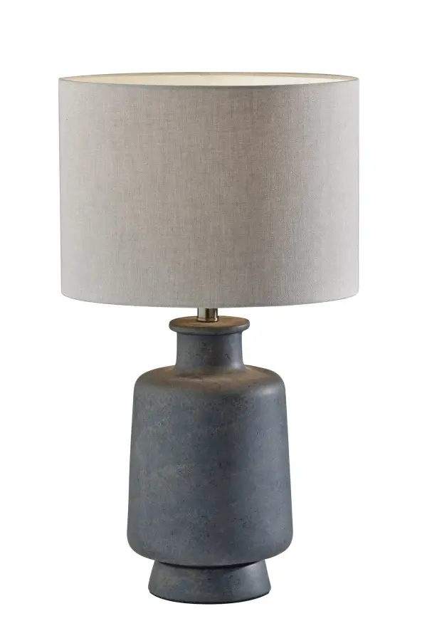 The Skylar Table Lamp brings subtle sophistication with its jug-shaped ceramic base in weathered grey and soft taupe fabric shade. Perfect for bedrooms and living spaces seeking organic texture and neutral tones.