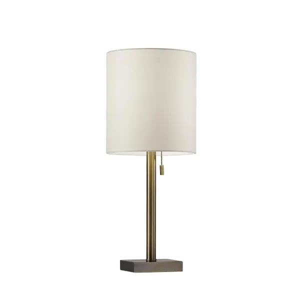 The Liam Table Lamp combines timeless antique brass with a clean cylindrical shade for versatile style. Its compact square base and 22-inch height make it perfect for bedside tables and small spaces seeking sophisticated lighting.