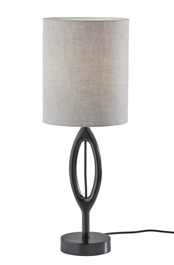 The Mayfair table lamp combines contemporary aesthetics with practical lighting. Its unique contoured black wood silhouette and visible grey fabric cord create visual interest, while the textured grey drum shade provides soft, diffused illumination.