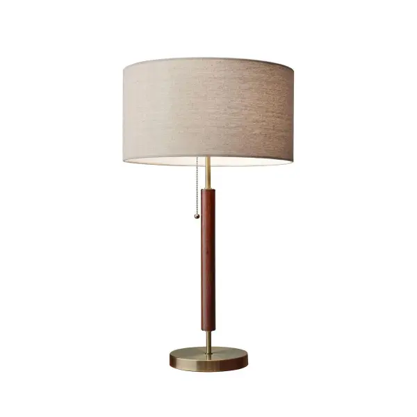 The Hamilton table lamp blends natural walnut eucalyptus wood with antique brass accents for a sophisticated mid-century aesthetic. Its natural linen shade provides warm, diffused light perfect for reading or ambient lighting.