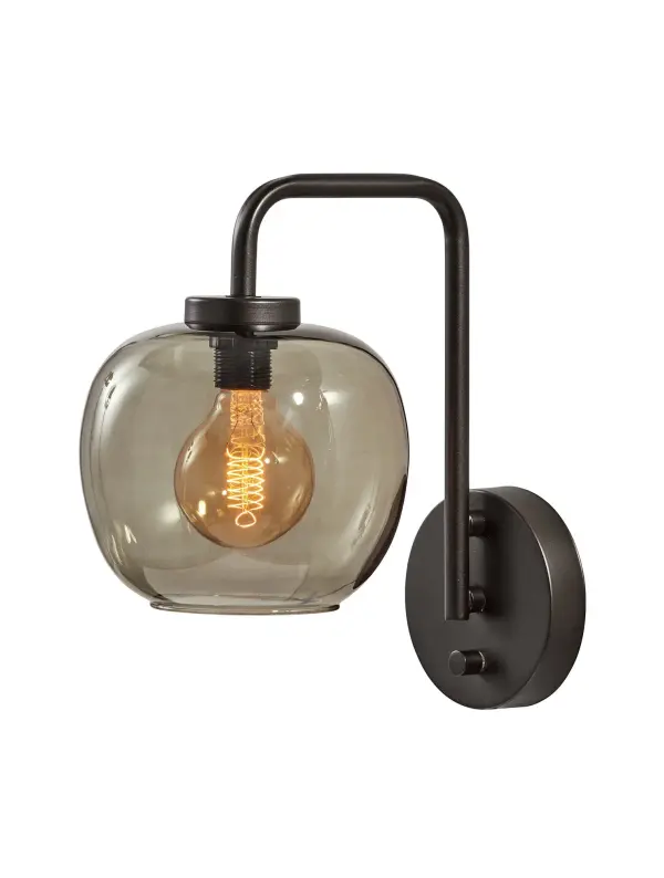 The Ashton Wall Lamp combines industrial style with modern convenience. Its smoked glass globe shade and matte black finish create sophisticated ambiance, while hardwire and plug-in compatibility offers flexible installation.