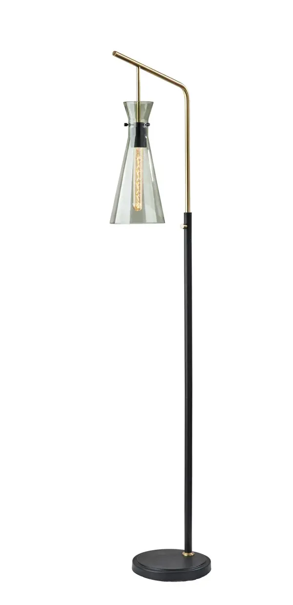The Walker floor lamp combines black metal with antique brass accents and a smoked glass shade for sophisticated industrial style. At 64" tall with a compact 18" footprint, it's perfect for corners or beside furniture. Includes vintage Edison bulb.