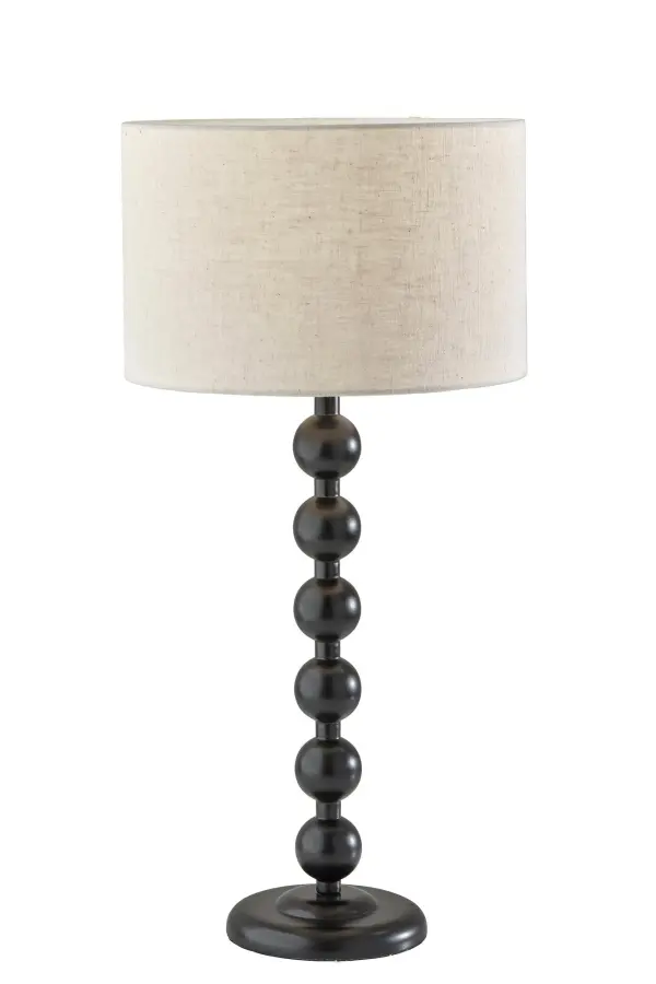 The Orchard table lamp combines sculptural black wood construction with a cream linen shade for sophisticated style. Its unique stacked ball stem design and 3-way switch offer both visual interest and functional flexibility.